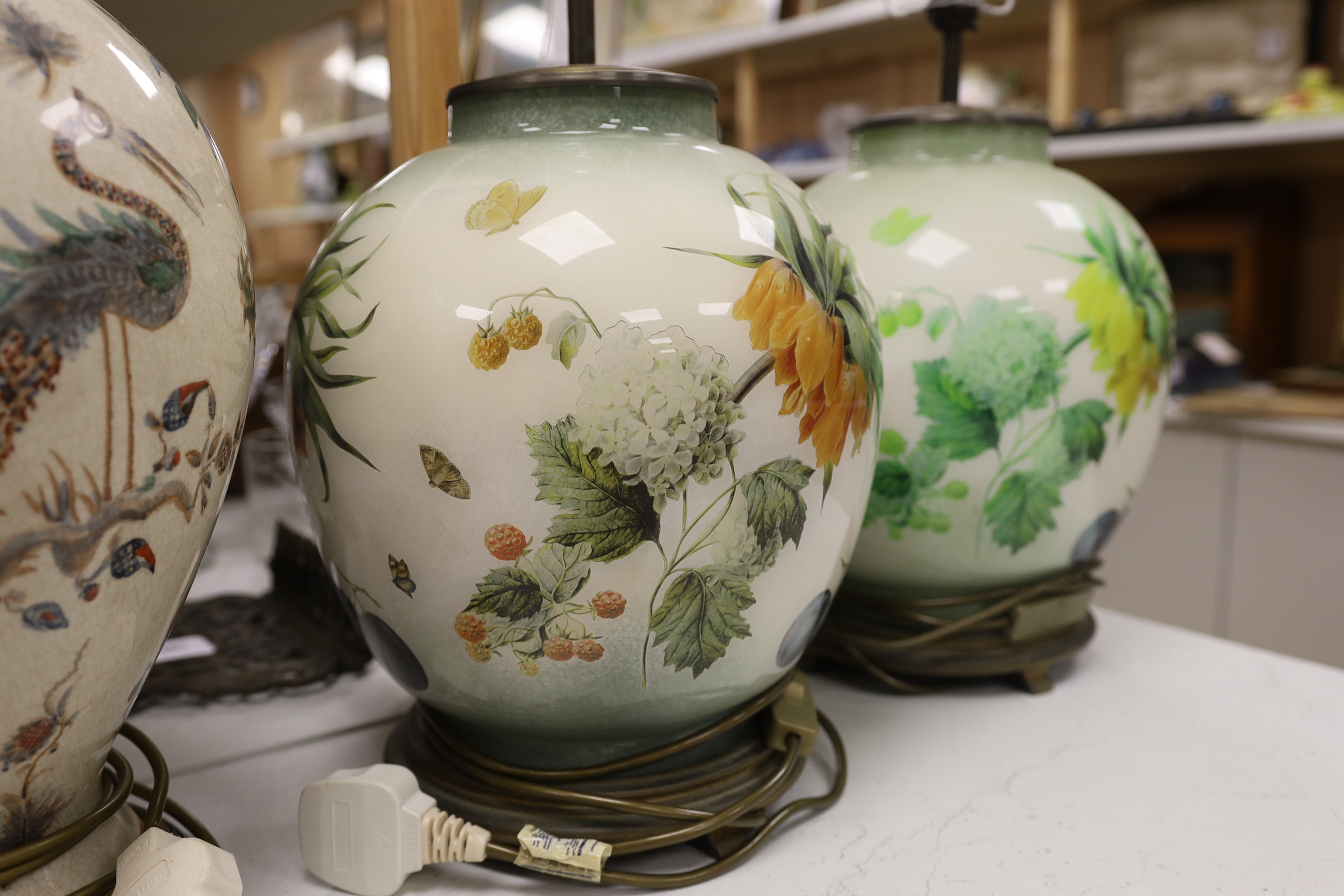 A pair of floral reverse decorated glass decorative table lamps and a similar crackle ware table lamp, 40cm not including light fitting